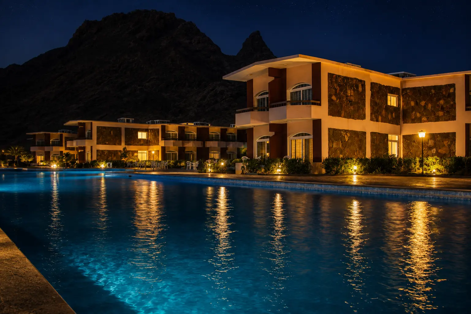 Guest buildings reflected in the pool at night