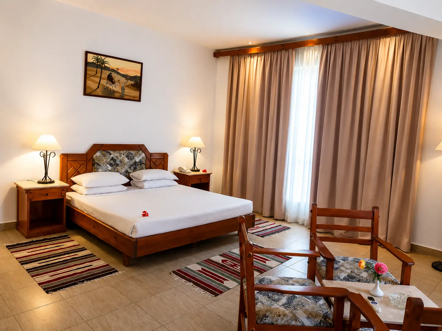 Spacious double room with wooden furniture and a seating area