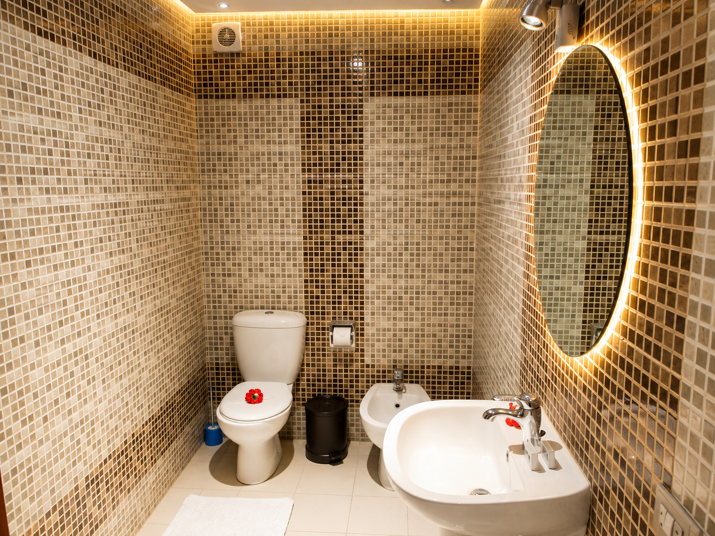 Modern tiled bathroom with a circular backlit mirror