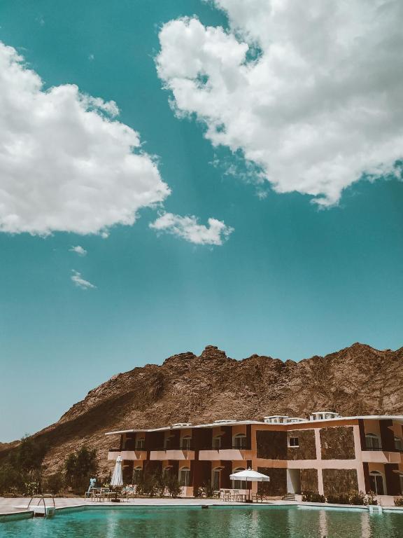 Daylight view of pink hotel buildings against a desert mountain backdrop